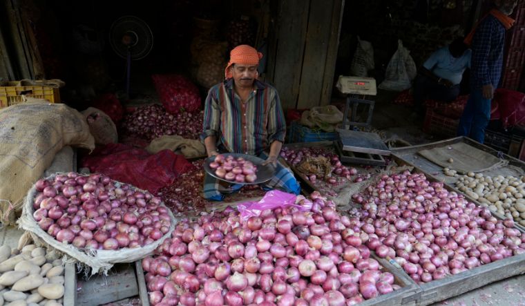 A vendor sells onions at a wholesale vegetable market in Prayagraj on April 28, 2024